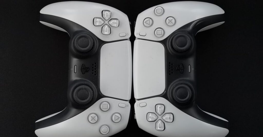 Top-down view of two modern white gaming controllers on a black surface.