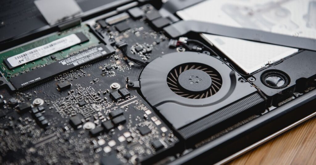 Detailed view of a laptop's internal circuitry and cooling fan showcasing technology and engineering.