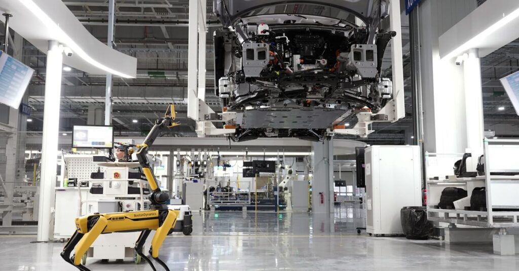 A robotic dog oversees an automated car assembly in a high-tech factory setting.