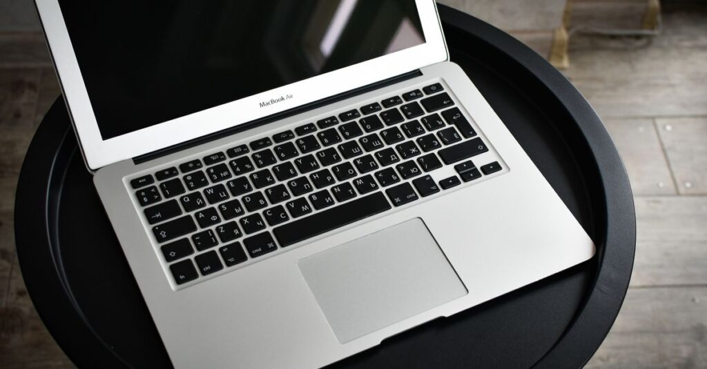 A stylish laptop sits elegantly on a black round table in an indoor setting, ideal for tech and workspace themes.