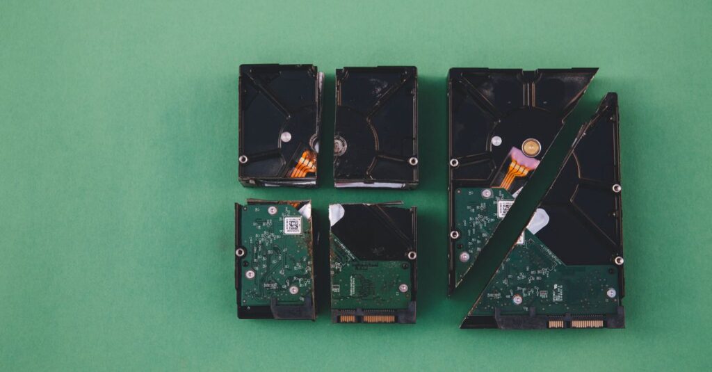 Four broken hard drives arranged on a green background, showcasing data destruction.