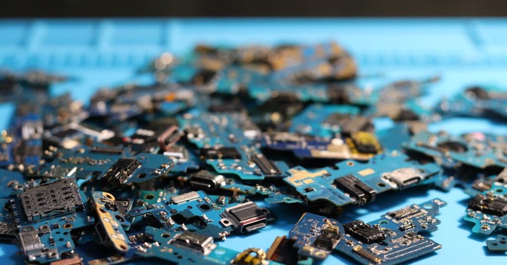 Pile of disassembled circuit boards on a blue surface. Perfect for tech themes.
