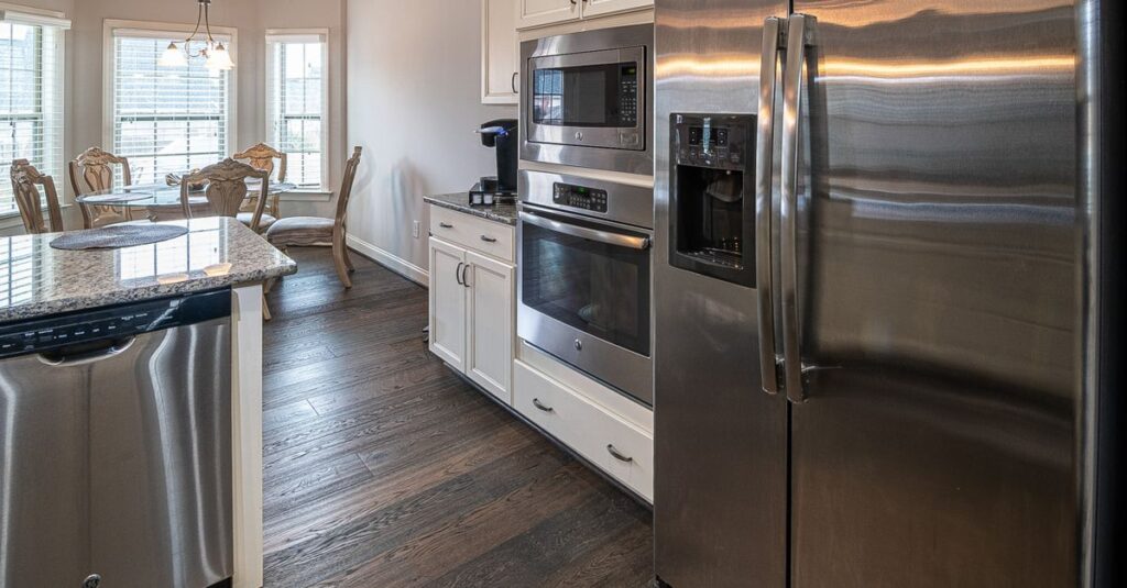 Spacious modern kitchen featuring stainless steel appliances and a dining area.