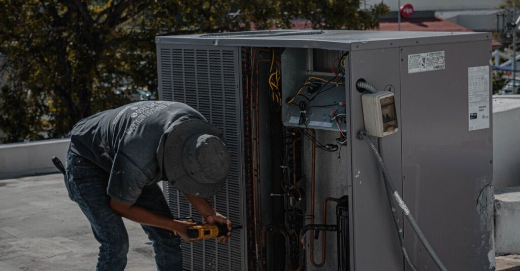 A technician is repairing an air conditioning unit on a rooftop, demonstrating skilled manual work.