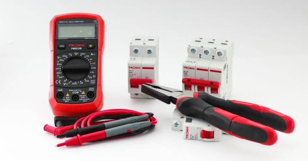 Close-up of a digital multimeter with electrical tools and circuit breakers on a white background.