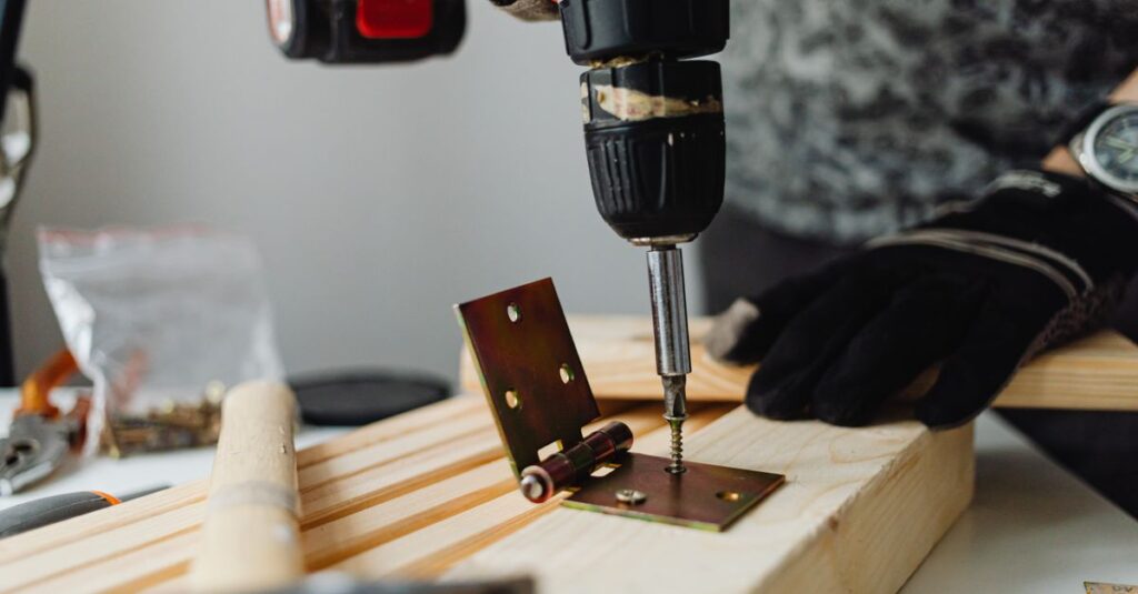 Close-up of a skilled carpenter using a power drill on wood in a workshop.