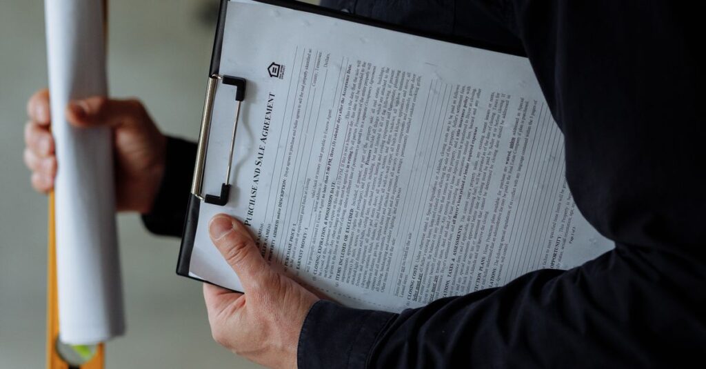 Architect wearing a face mask holds blueprints and clipboard, emphasizing safety measures.