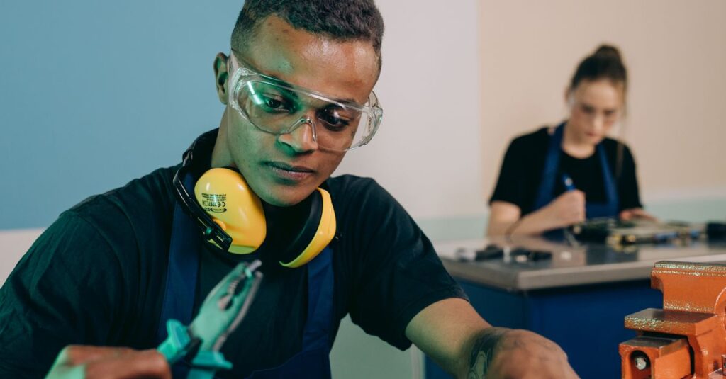 Two technicians carefully working with tools in a modern workshop.