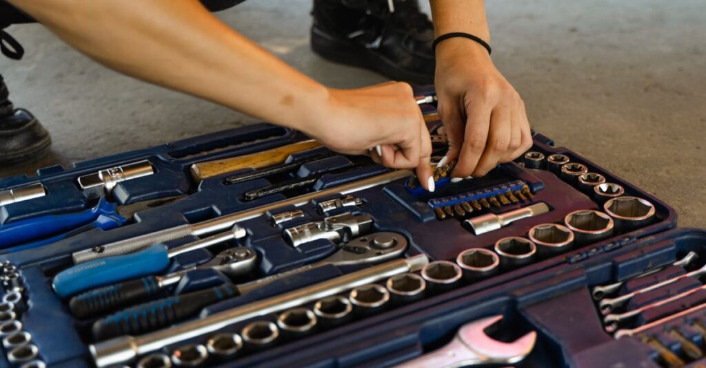 Hands selecting a tool from a versatile, well-organized toolbox for repair tasks.